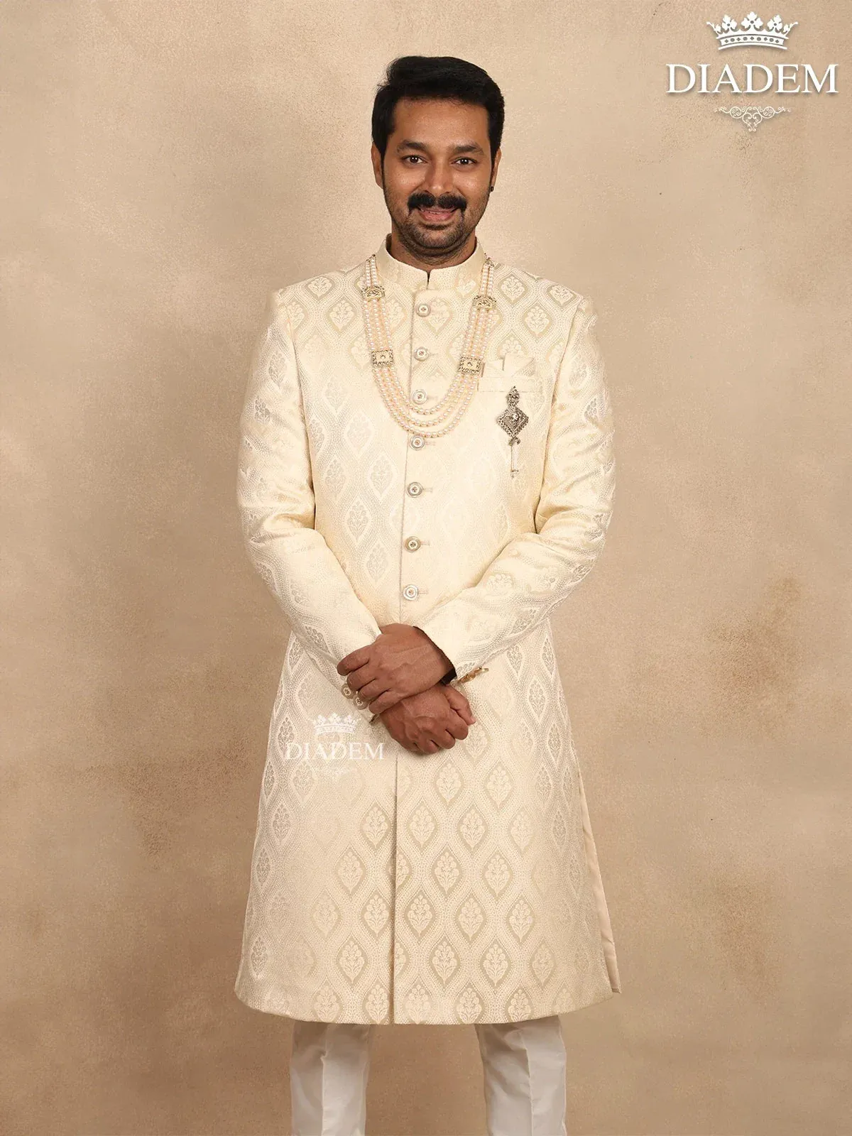 Cream Raw Silk Sherwani Suit Adorned with Floral Embroidery, Paired with Brooch and Bead Mala